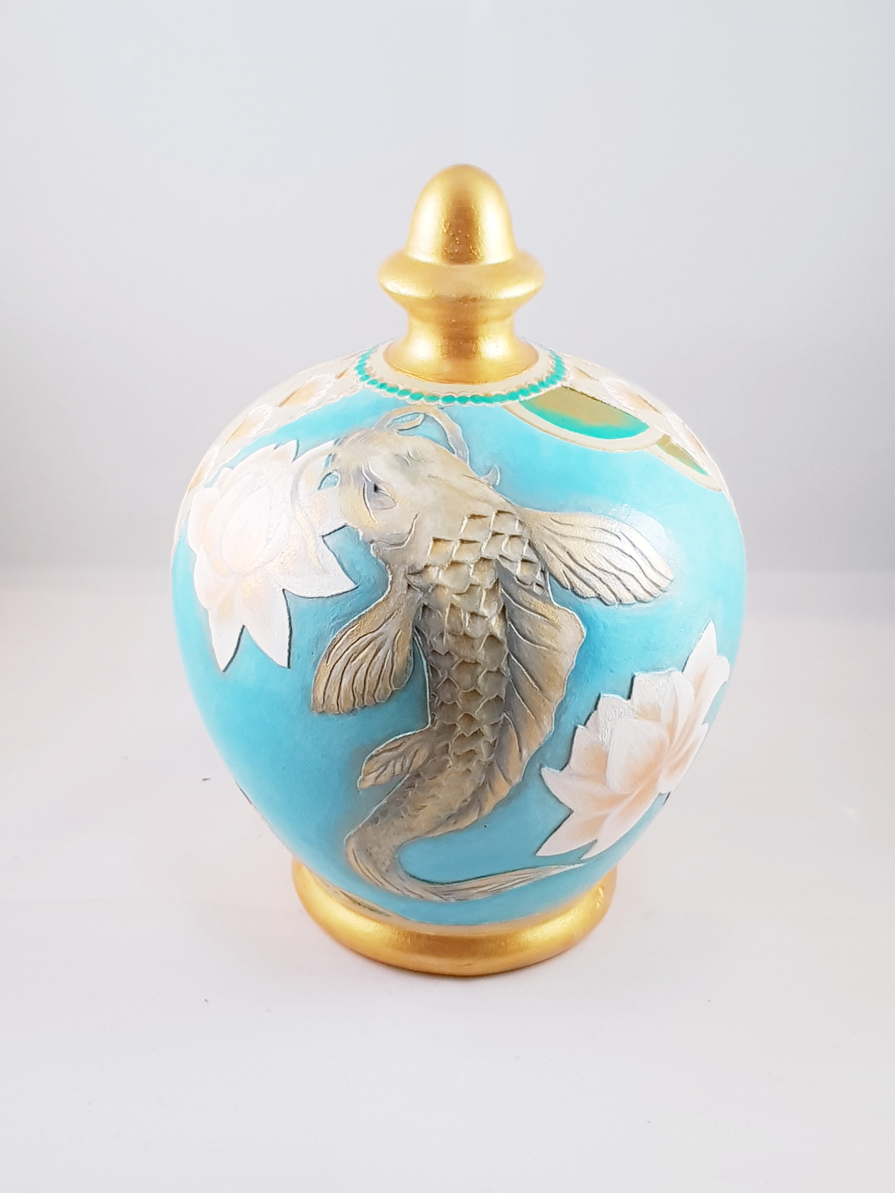 Engraved and painted koi fish on ceramic piggy bank.